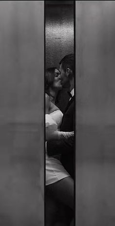 a man and woman kissing in an elevator