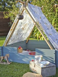 an outdoor play area with a teepee tent and toys