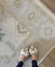 a woman standing on top of a rug with her feet propped up against the carpet