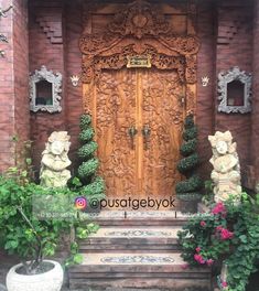 an ornate wooden door surrounded by potted plants