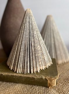 an open book sitting on top of a wooden table next to two small brown cones