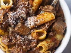 a white bowl filled with pasta and meat