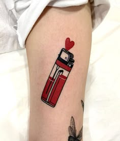 a woman's leg with a red lighter tattoo on her left thigh and a heart in the middle