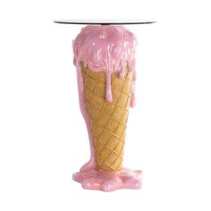 an ice cream cone with pink glaze on it sitting in front of a white background