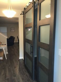 the interior of a house with wood floors and glass doors that lead to an entry way