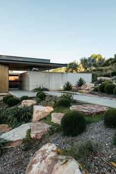 the house is surrounded by rocks and plants