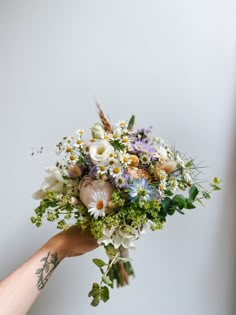 a person holding a bouquet of flowers in their hand