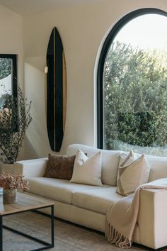 a living room with large arched windows and white couches in front of the window