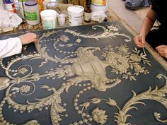 two people are working on an ornate design