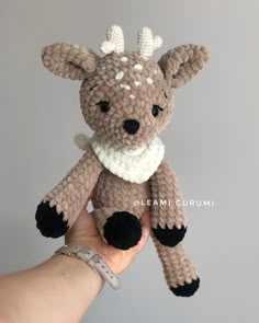 a hand holding a small crocheted stuffed animal in the shape of a deer