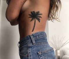 a woman with a palm tree tattoo on her back