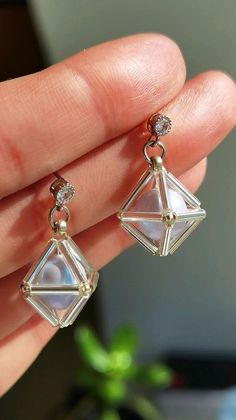 a pair of earrings is shown in someone's hand