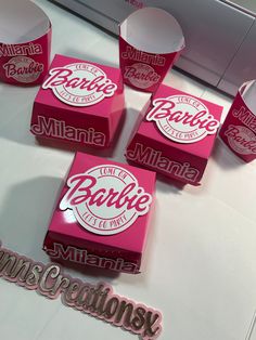 several pink boxes with the word barbie on them sitting on a white counter top next to each other