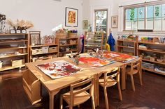 a room filled with lots of wooden furniture and art work on the tables in front of them