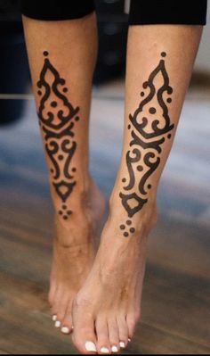 a woman's legs with hennap tattoos on them