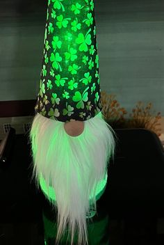 a green hat with white fur and shamrocks on the top is sitting on a table