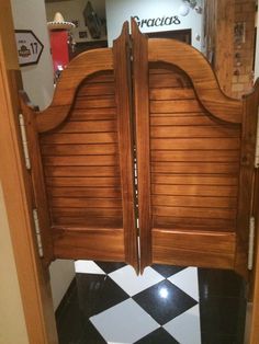 an open wooden door with black and white checkered flooring