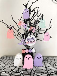 there is a small tree with ghost decorations on it