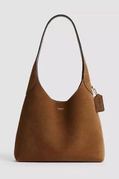 The Coach Brookly 28 Cedar Suede Hobo. Simple and beautiful - and sold out everywhere. For more on fall’s best suede bags head to the blog. Tan Suede