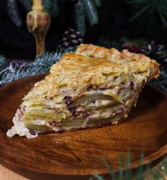 a piece of pie sitting on top of a wooden plate next to a christmas tree