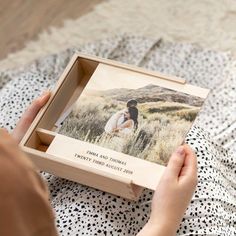 a person holding a wooden box with a photo inside