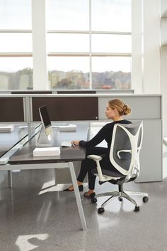 a woman sitting at a desk using a computer