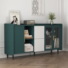 a green cabinet with two doors and some books on it in a white walled room