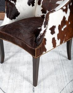 a cow print chair sitting on top of a rug