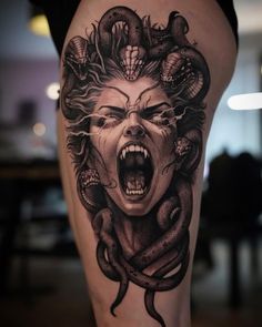 a woman's thigh with an evil face and snakes on it