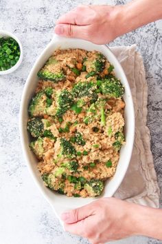 broccoli and rice casserole in a white dish next to a bowl of peas