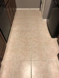 a kitchen with tile floors and brown cabinets