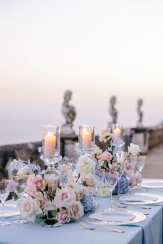 the table is set with flowers and candles