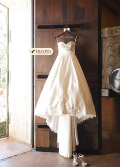 a wedding dress hanging up on a door