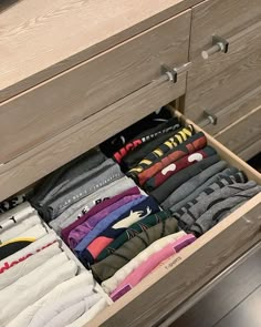 an open drawer with several pairs of shirts in it