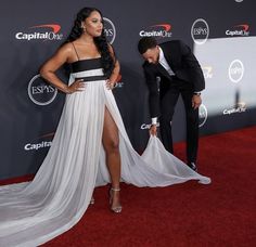 a woman in a white and black dress standing next to a man