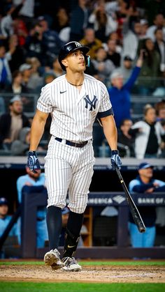 a baseball player holding a bat on top of a field in front of a crowd