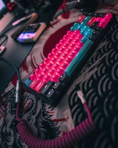 a red and blue keyboard sitting on top of a desk next to a computer mouse