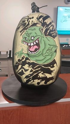 an odd looking rock sitting on top of a wooden table next to a computer monitor