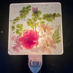 a close up of a flower on a glass surface with flowers painted on the side