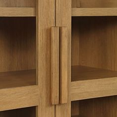 an oak bookcase with glass doors and no one in the room to see it