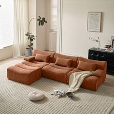 a living room with a large sectional couch in the middle and a rug on the floor