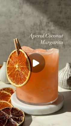 an image of a drink with oranges on the side and text that reads aperol coconut margarita