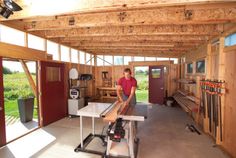 a man standing in a room with lots of wood on the walls and flooring