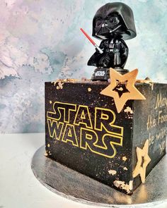 a star wars themed cake with a darth vader figure on top and stars around it