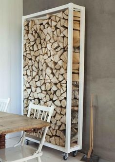 a table and chairs in front of a firewood rack