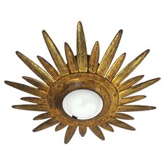 an antique brass sunburst light fixture on a white background