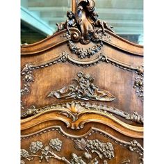 an ornate wooden bed frame with carvings on it