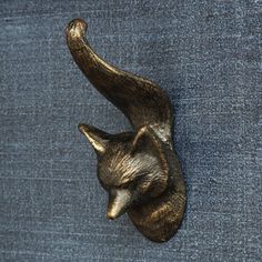 a metal animal head mounted to the side of a blue cloth covered wall in front of a wooden frame