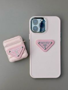 an iphone case with a pink prada logo on it next to a phone holder