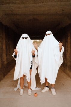 two people dressed in white standing next to each other